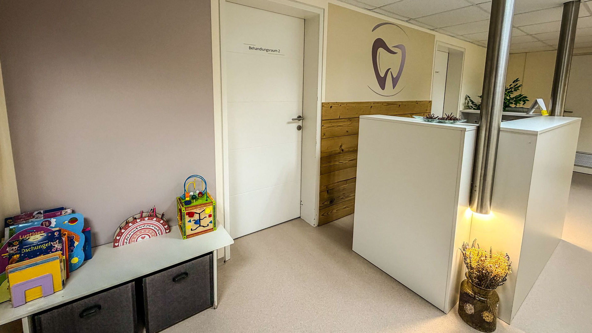 Behandlungsraum mit Zahnarzt-Logo